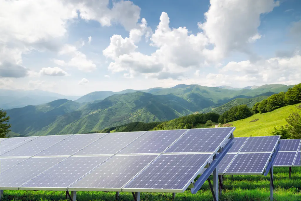 Solar tracking system with mountains in the background.