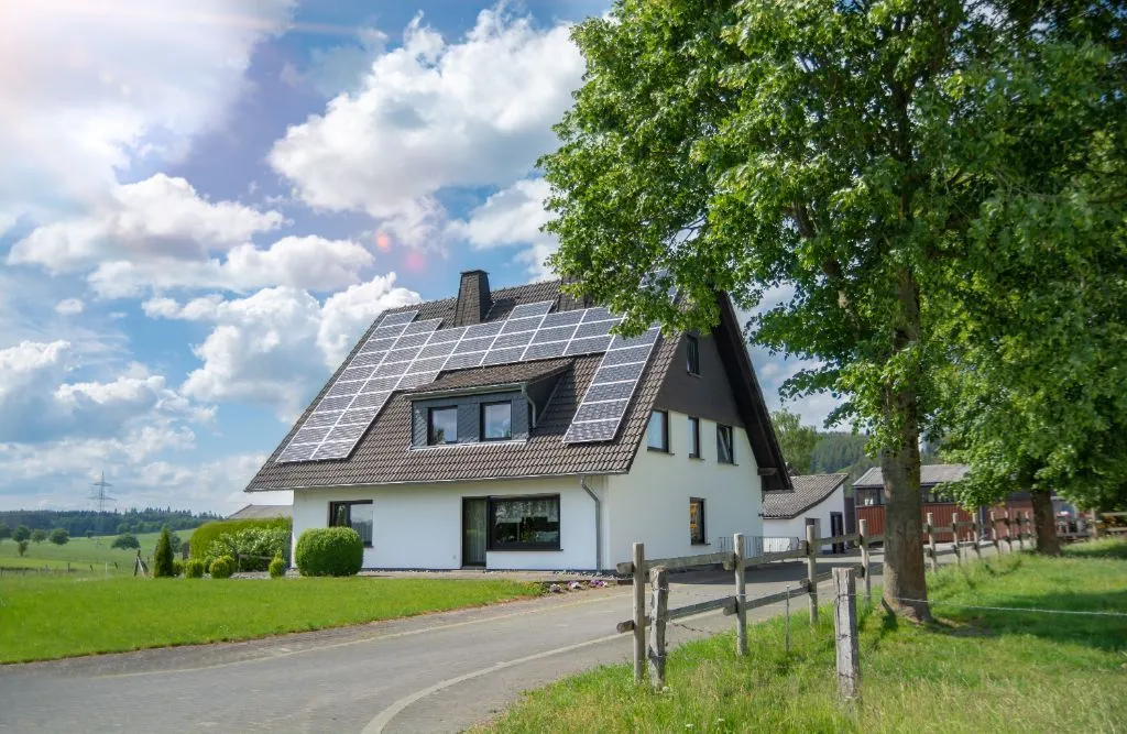 A modern house in the village with solar panels on the roof