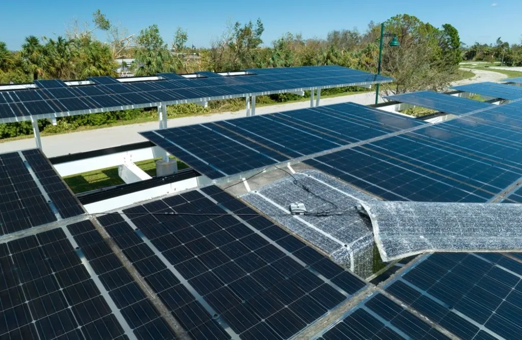 Wind damage to solar panels installed over parking lot canopy shade for parked cars