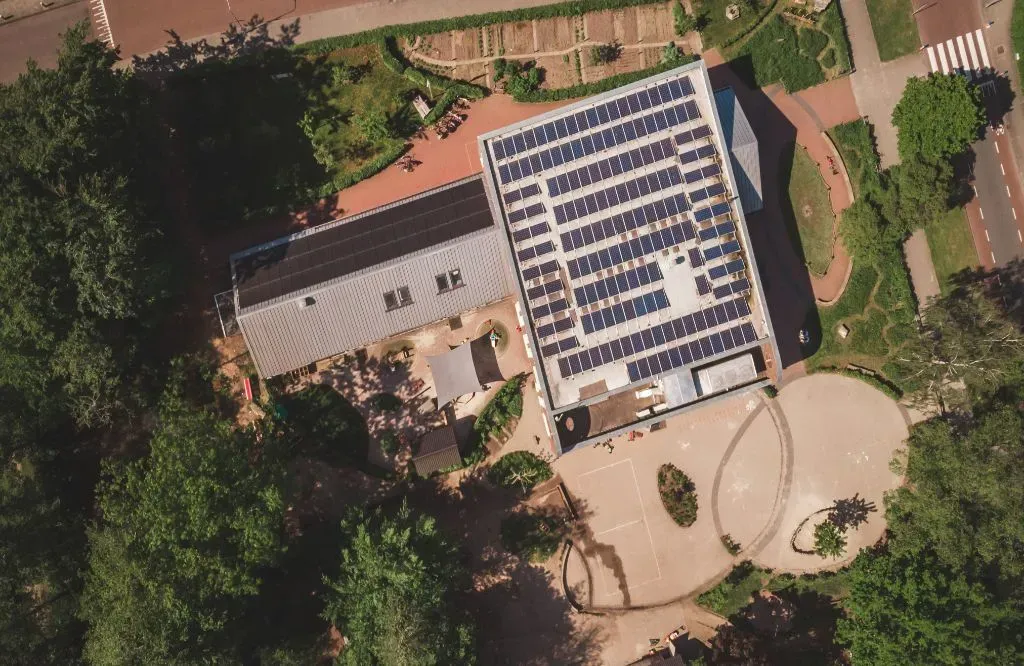 An aerial view of a building with solar panels on the roof.