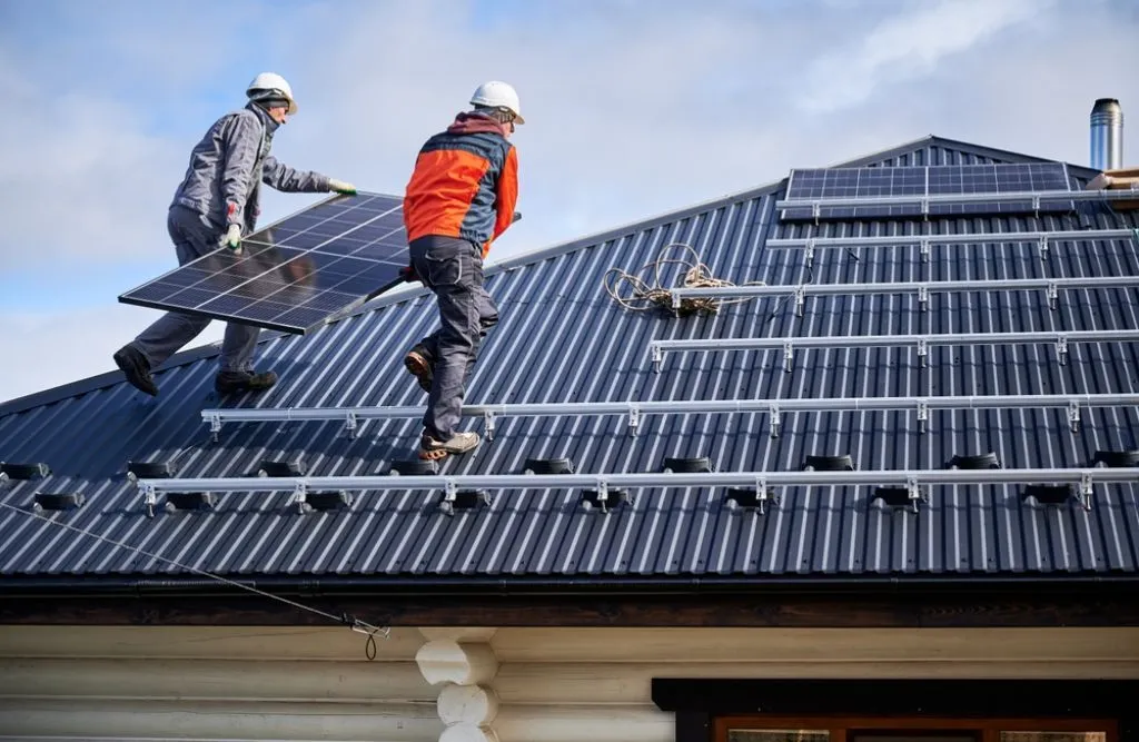 A couple of workers building a residential solar panel system.