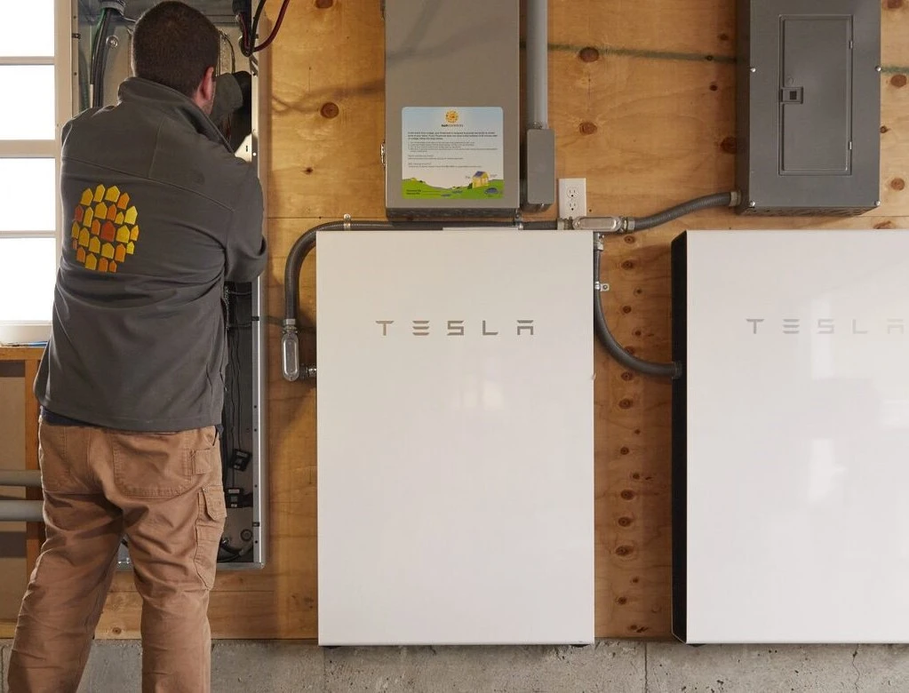 Technician installing and monitoring Tesla Powerwall battery performance
