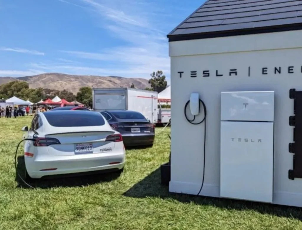 Tesla Powerwall battery with an electric car being charged outdoors